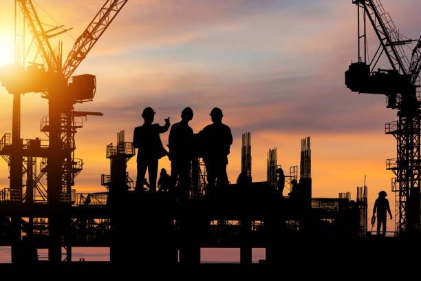 istock Silhouette of Engineer and worker on building site, construction site at sunset in evening time 1354362355