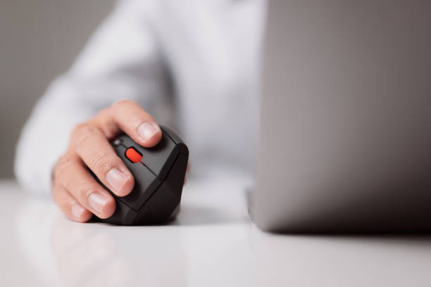 The man who works from his house. A close-up of a hand with a computer mouse that is both comfortable and ergonomic. Working on the notion of COVID-19. The man who works from his house. A close-up of a hand with a computer mouse that is both comfortable and ergonomic. Working on the notion of COVID-19. ergonomics-mouse stock pictures, royalty-free photos & images