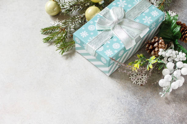 istock Christmas or New Year holidays composition layout. Fir tree snow branch, Christmas present and decoration on a stone tabletop. Copy space. 1354366302