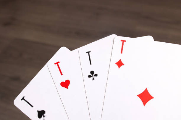 istock Four aces close up on wooden background 1354367456