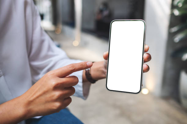 istock a woman holding and pointing finger at a mobile phone with blank white screen 1354367534