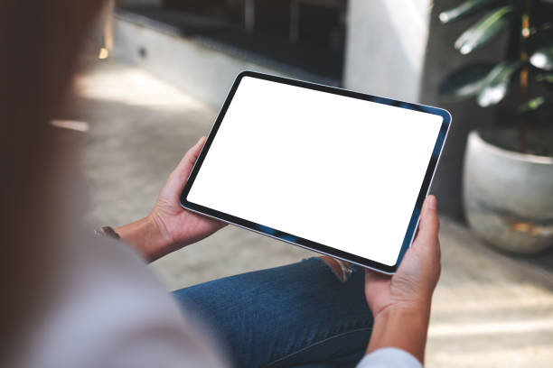 istock a woman holding digital tablet with blank white desktop screen in cafe 1354367536