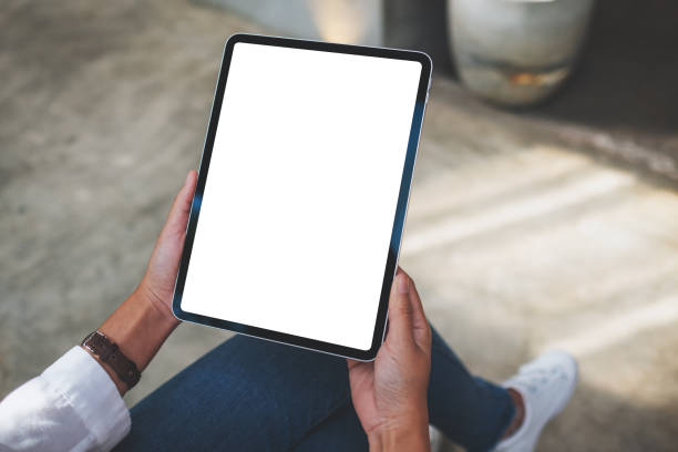 istock a woman holding digital tablet with blank white desktop screen in cafe 1354367557