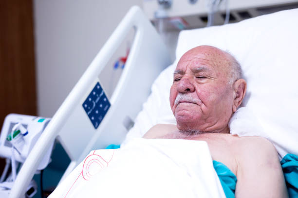 istock Sick and Senior Man Wearing Hospitable Gown Lying in Bed 1354369516