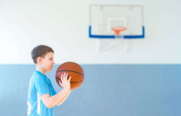 istock Side View Of Boy Playing Basketball 1354370914