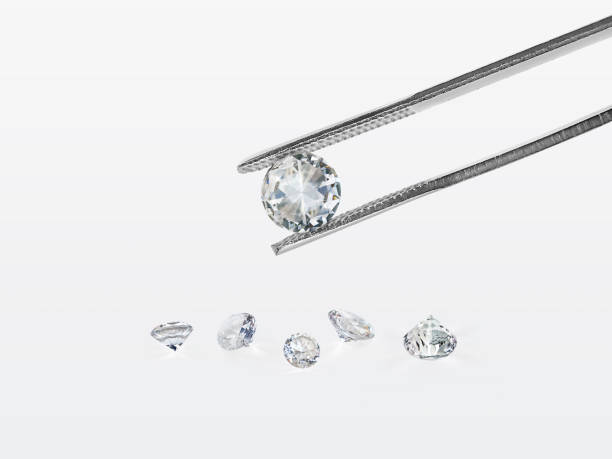 istock brilliant cut diamond held by tweezers isolated on white background 1354372798