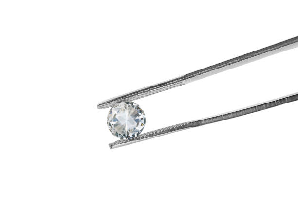 istock brilliant cut diamond held by tweezers isolated on white background 1354372811