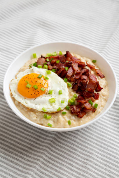 istock Homemade Cheesy Bacon Savory Oatmeal Bowl on cloth, side view. 1354374659
