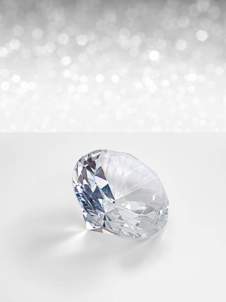 istock Dazzling diamond on white shining bokeh background. concept for chossing best diamond gem design 1354375592