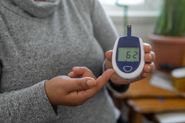 Woman checking her glucose level Woman checking her glucose level blood sugar test stock pictures, royalty-free photos & images