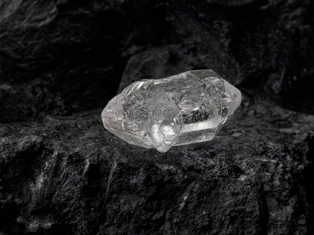 istock Natural diamond nestled on black coal background 1354378199