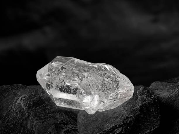 istock Natural diamond nestled on black coal background 1354378206