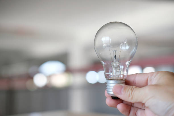 istock Hand holding a light bulb on a table, notion of idea creativity and inspiration, future technologies 1354379775