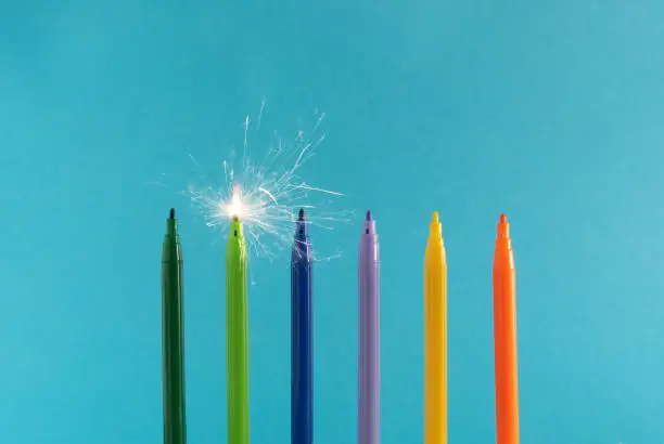 Photo of Creative layout made of colorful felt tip pens on blue background. holiday concept.