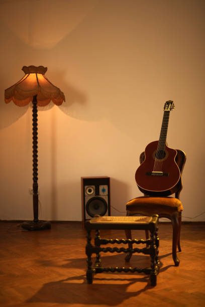 istock Acoustic guitar in a retro vintage room. 1354380704