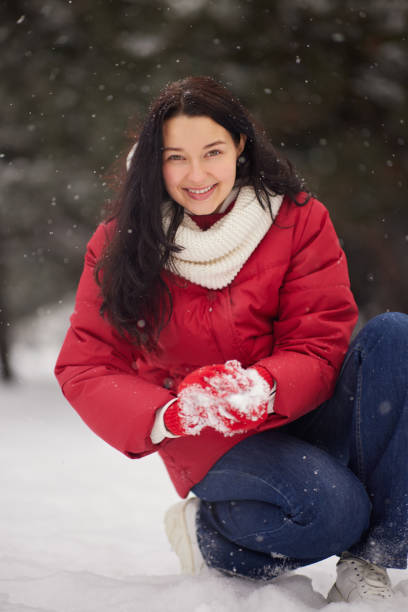 istock Woman Playing Winter Game Making Snowball in Park 1354384365