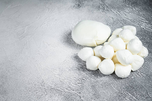 istock Mozzarella cheese mini balls on kitchen table. White background. Top view. Copy space 1354385323