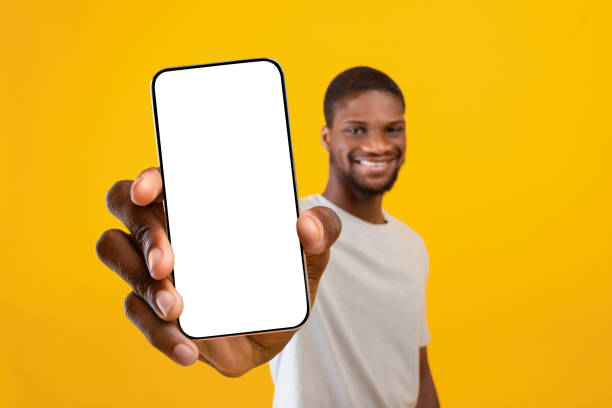 istock Happy black man showing mobile phone with blank display 1354385704