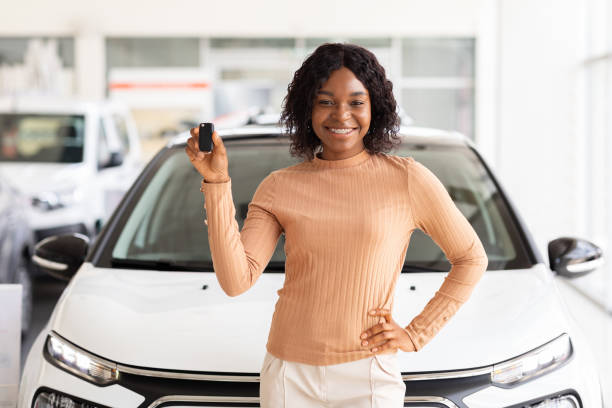 glückliche afroamerikanische frau, die nach dem kauf die schlüssel ihres neuen autos hält - new automobile stock-fotos und bilder