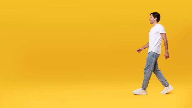 istock Young bearded man walking isolated on yellow background, panorama 1354387159