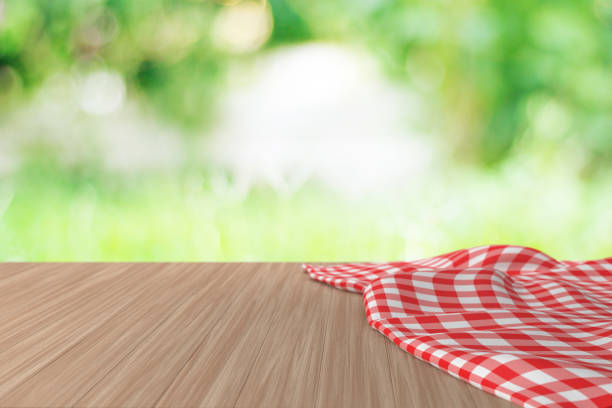 istock Empty Wooden Table with Crumpled tablecloth And Blurred Green Nature Background. 1354387993