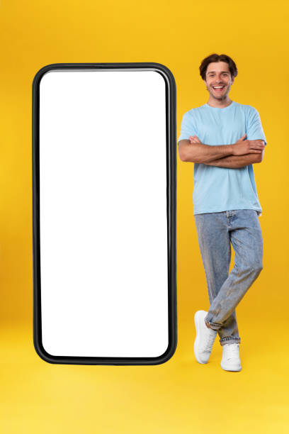 istock Man standing near big white empty smartphone screen 1354388415