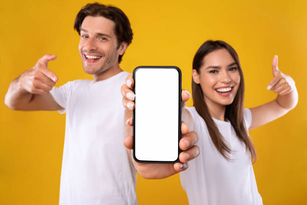 istock Couple showing blank empty white smartphone screen for mock up 1354388462