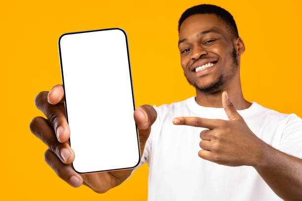 istock Cheerful handsome black guy with cellphone, mockup 1354388673