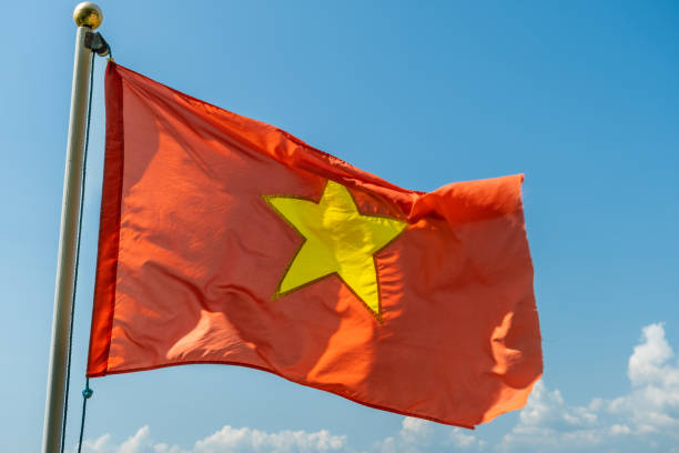 Close up of the red Vietnam National Flag with a gold star in the middle, flying in the sky stock photo