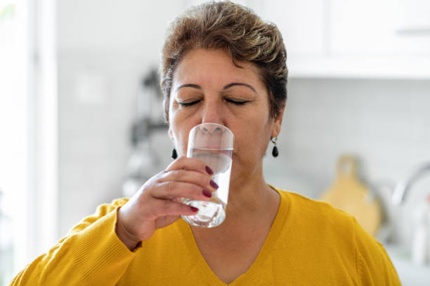 istock Woman drinking from a glass of water 1354390149
