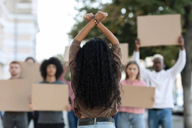 istock Unrecognizable long-haired woman leading group of protestors 1354391097