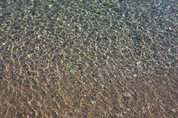 Pebble stones transparent sea water background