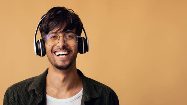 istock Laughing arabic guy enjoying brand new wireless headset 1354392073