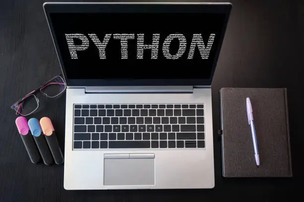 Python inscription on laptop screen and keyboard. Learn python programming language, computer courses, training.