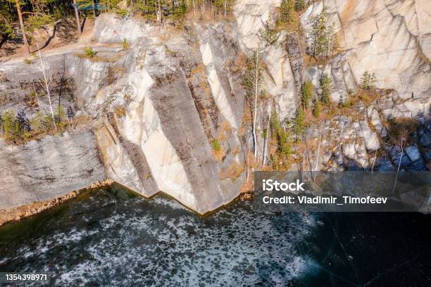 Edge Of The Forest On The Rock Of A Stone Quarry With Water A View From A Drone Stock Photo - Download Image Now