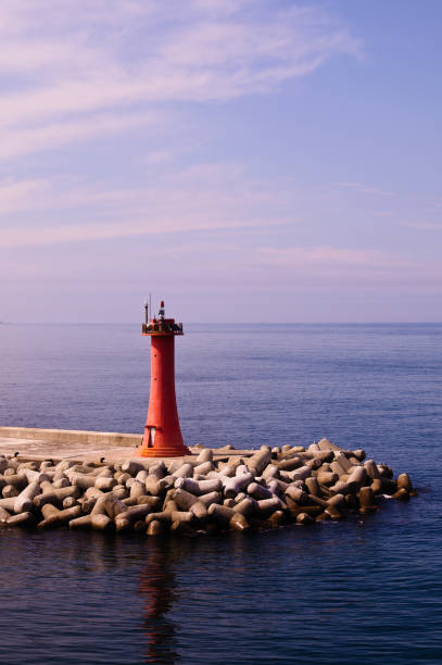 istock Mini Lighthouse on the coast. small red lighthouse on the pier 1354400173