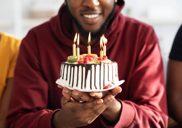 Cropped of black birthday man holding cake with lit candles