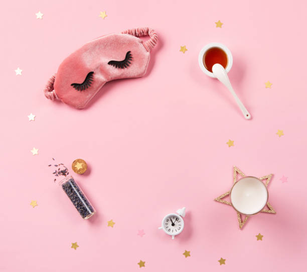 istock Cute sleeping mask, candle, lavender and alarm clock on pink pastel background, top view. 1354401419