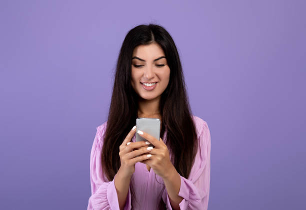 comunicación moderna. feliz mujer armenia navegando en el teléfono inteligente, enviando mensajes o desplazándose por el feed de las redes sociales - armenian ethnicity fotografías e imágenes de stock