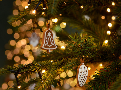 Christmas gingerbread decoration on a Christmas tree on golden bokeh background