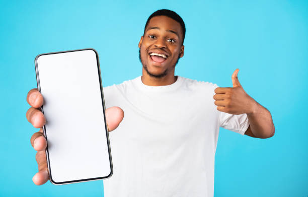 istock Emotional black man demonstrating smartphone with empty screen 1354402972