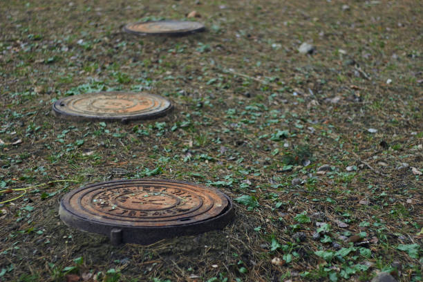 istock Rusty manhole cap grunge manhole cover with clipping path forest background grass 1354403073