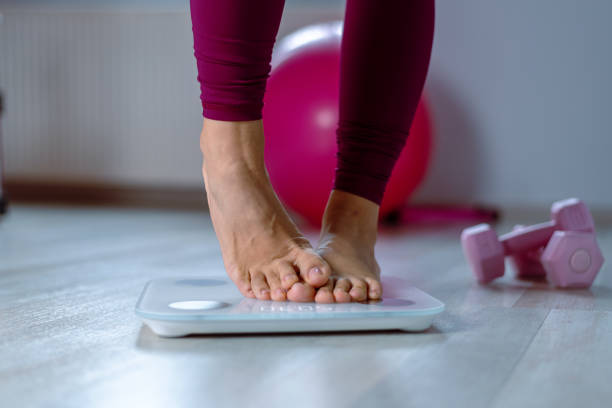 istock Fit woman's feet on scale 1354404299