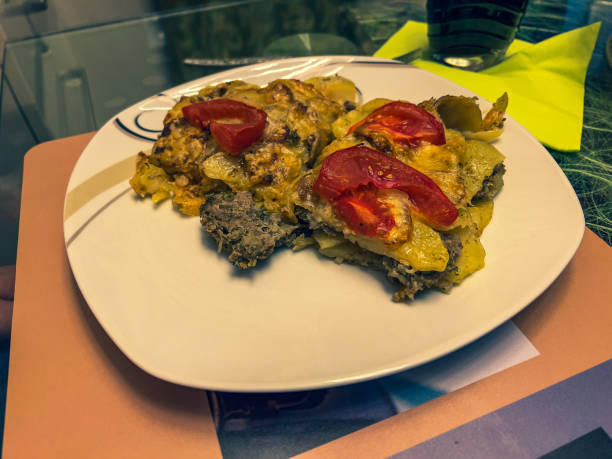 Oven potatoes with meat tomatoes and cheese gratinated.