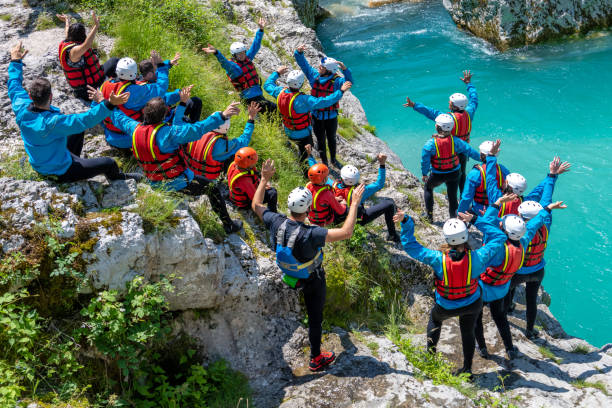 istock Adventurous team encouraging themselves before jumping info cold mountain water from rock 1354408357