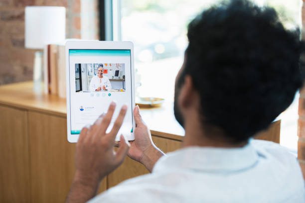 istock Young man greets doctor during telemedicine appointment 1354411908