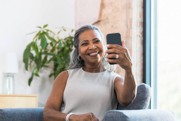 istock Smiling senior woman taking selfie 1354411931