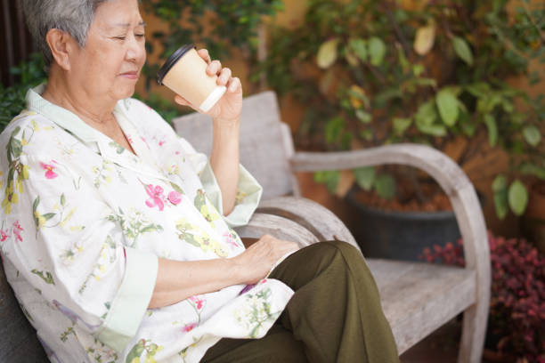 istock old elderly senior elder woman drinking hot coffee in garden 1354412016