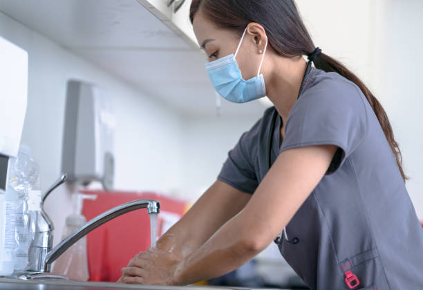 nurse rinsing off her hands - exfoliating scrub imagens e fotografias de stock