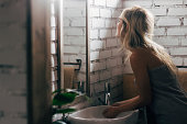 Beautiful Blonde Woman Washing her Hands in the Bathroom Sink